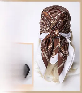 Macro shot of silk-like scarf texture with golden chain and houndstooth print patterns