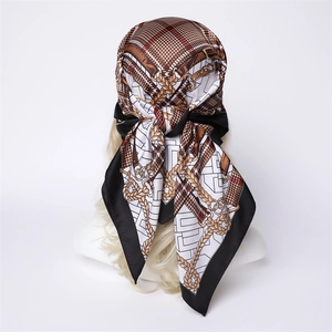 Detail of silk-feel scarf with plaid and golden chain pattern tied on a mannequin