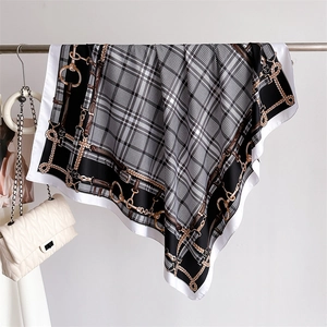 Detail of checkered silk-feel scarf with golden chain patterns and satin texture