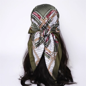 Plaid chain pattern silk scarf tied as a headwrap on model with long dark wavy hair