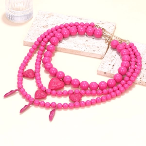 Collier bohème à trois rangs de perles roses avec pendentifs cœur et fermoir doré