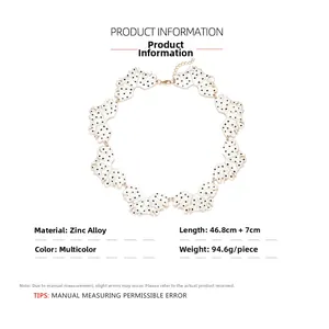 Detailed view of handmade enamel leaf necklace with white surface and black dots