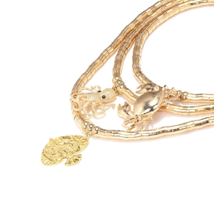 Detailed close-up of golden multi-layer necklace with crab, octopus, and fish pendants