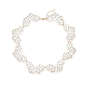 Exaggerated enamel leaf necklace with black polka dots on white fan-shaped petals