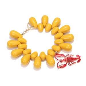 Detailed shot of yellow teardrop beads necklace featuring a vibrant red lobster pendant