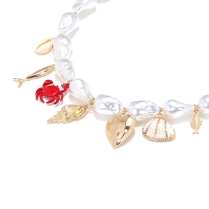 Detail of baroque pearl necklace with gold ocean charms, sea shell and red crab pendant
