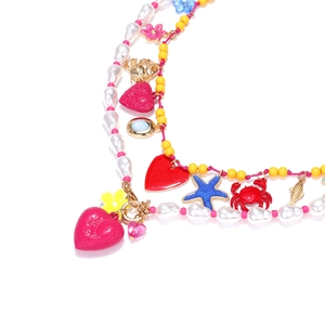 Detail of bohemian layered necklace with colorful beads, starfish, and heart charms