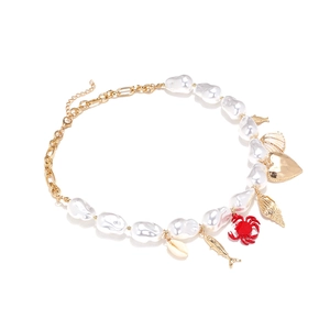 Baroque pearl necklace with gold crab heart shell charms in a coastal nautical style