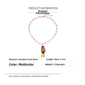 Detailed view of handmade beaded fish necklace with adjustable chain and imitation pearls