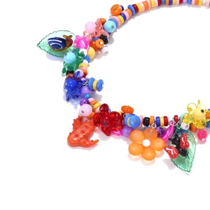 Macro detail of colorful beaded necklace with floral and insect pendants for women