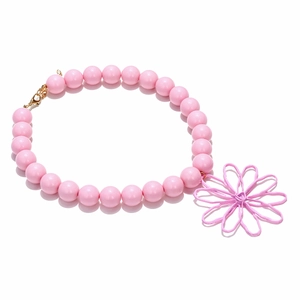 Close-up of pink beaded necklace with large hollow flower pendant and gold lobster clasp