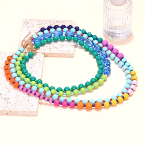 Detail view of multi-layer colorful beaded necklace with gold lobster clasp and chain
