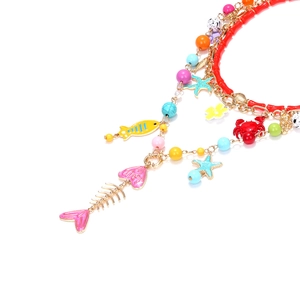 Détail du collier de perles avec étoile de mer, crabe doré et éléments marins colorés