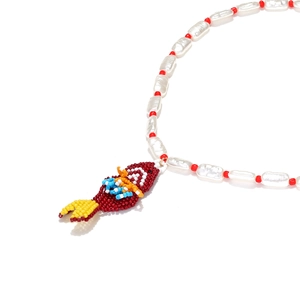 Macro detail of handmade beaded tropical fish pendant with white freshwater pearls
