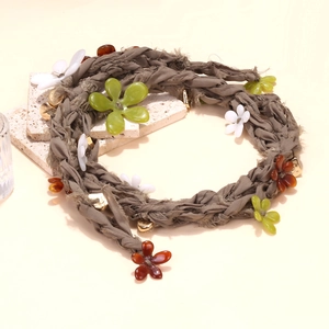 Detail of bohemian hand-woven gray flower necklace with resin petals and gold beads