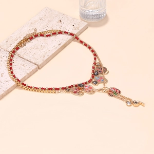 Gelaagde gouden ketting met rode kralen, schedel hart hangers en fluitje hanger