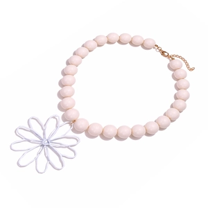 Detail of beaded necklace featuring off-white pearls and large wire daisy flower pendant