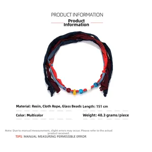 Detail of colorful resin and glass beads on a long bohemian tie-dye fabric cord necklace