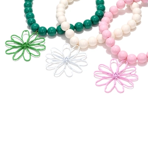 Detailed macro view of colorful beaded bracelets with floral pendants in pastel tones
