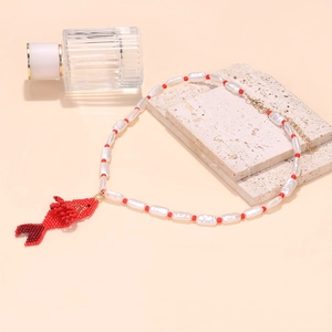 Detailed view of handmade beaded tropical fish pendant necklace with baroque square beads