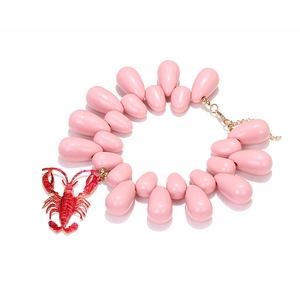 Detailed shot of beaded necklace with a red lobster pendant and pink teardrop beads