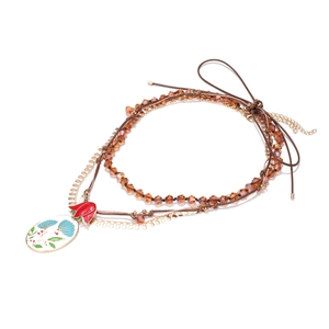 Handmade beaded layered necklace featuring enamel flower pendant and amber glass beads