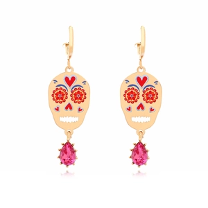 Detail van schedeloorbellen met bloemmotieven en roze traankristal in gouden zetting