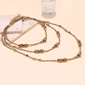 Detail of layered gold and silver metallic beads with adjustable lobster clasp closure