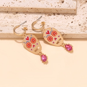 Detail van schedeloorbellen met rode harten, bloemmotieven en roze edelsteenhangers