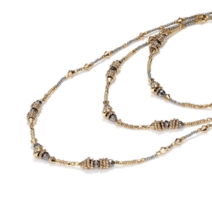 Macro shot of multi-layer beaded necklace with gold and silver geometric textured beads