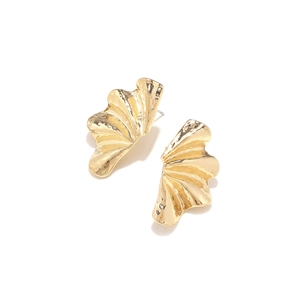 Close-up of golden leaf earrings featuring a vintage hammered texture and wavy edges