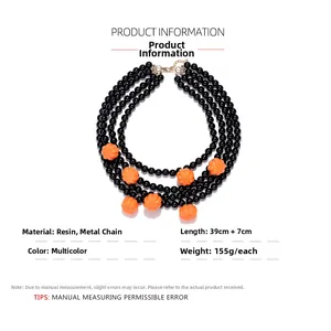 Detail of multi-layered beaded necklace with orange pumpkin charms and black beads