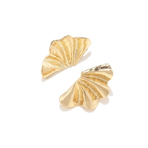 Detailed close-up of golden alloy leaf earrings with textured radial fan patterns