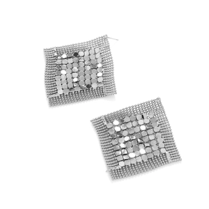 Dettaglio di orecchini geometrici in argento con paillettes metalliche e bordo con perline