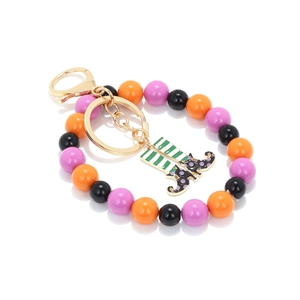 Close-up of Halloween keychain featuring striped witch boots and festive colored beads