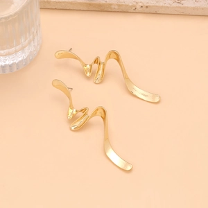 Close-up of elegant gold irregular wave-shaped earrings with a polished metallic texture