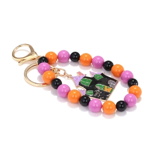 Detail of Halloween keychain featuring a black haunted house charm and colorful beads