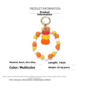 Detail of Halloween stacked pumpkin charm keychain with colorful resin beads and gold ring