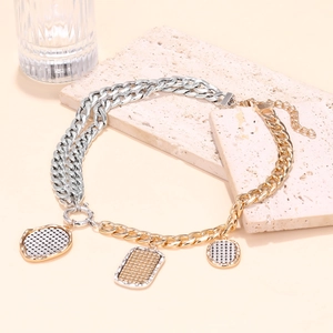 Two-tone mixed metal chain necklace with geometric textured coin pendants on stone base