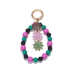 Detail of Halloween keychain with gold clasp, colorful beads and spider web charms