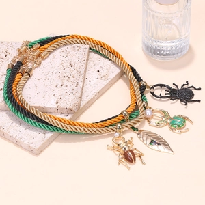Ensemble de trois colliers superposés avec pendentifs scarabées et feuille dorée