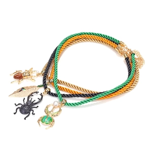 Lot de trois colliers en cordon avec pendentifs scarabée et feuille en doré et vert