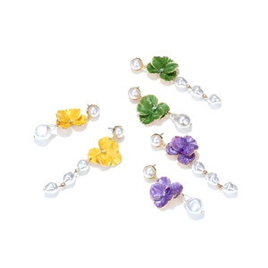 Detail view of colorful enamel flower earrings with baroque pearls in yellow green and purple