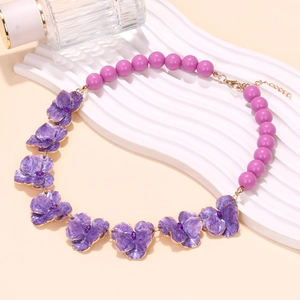 Collier de fleurs en émail et perles violettes sur présentoir à vagues blanc