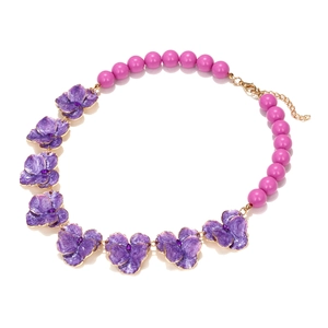 Détail du collier floral en émail avec pétales violets, perles roses et fermoir doré