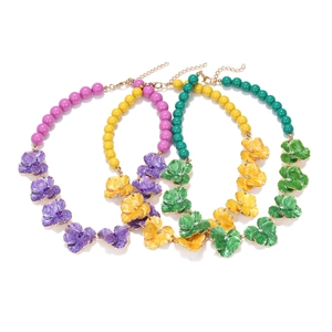 Détail de colliers de fleurs en émail coloré avec perles acryliques et fermoir doré chic