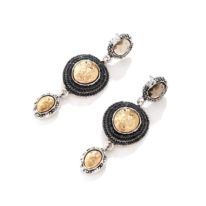 Detailed view of vintage geometric drop earrings with black rhinestones and matte gold finish
