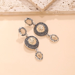 Macro detail of vintage palace-style drop earrings with amber stones and black crystals