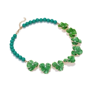 Détail du collier floral en émail vert avec maillons dorés et perles de résine