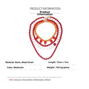 Detail of multi-layered beaded necklace with resin beads and strawberry pendant